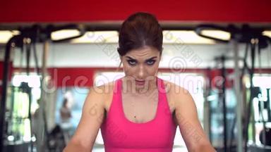 <strong>肌</strong>肉发达的女运动员穿着<strong>粉</strong>红色上衣在<strong>健身</strong>房锻炼举重。 <strong>健身</strong>女孩在<strong>健身</strong>房锻炼。 这就是